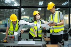 Group of engineers and technicians learning the technology to control hand robots for industrial usage. photo