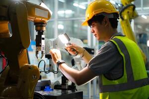 Technician who maintains a small robot arm the operation of a small robot arm used in industry is being repaired. photo