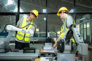 grupo de ingenieros y técnicos aprendizaje el tecnología a controlar mano robots para industrial uso. foto