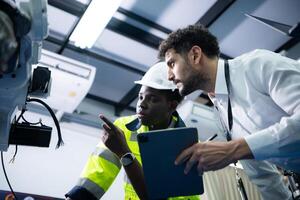 técnicos son presentando industrial mano robots a persona de negocios de fábrica industria quien será utilizar ellos en Gran escala complejo fabricación operaciones. foto