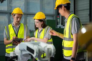 Engineer and technician discussing the robotic arm in factory about work operating, maintenance and repair photo