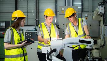 Engineer and technician discussing the robotic arm in factory about work operating, maintenance and repair photo