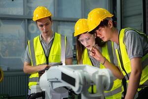 Engineer and technician discussing the robotic arm in factory about work operating, maintenance and repair photo