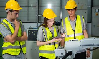 Engineer and technician discussing the robotic arm in factory about work operating, maintenance and repair photo