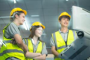 Both of young factory worker wearing a hard hat looking at a computer screen used to control production. photo