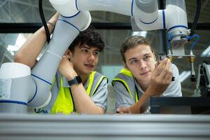 grupo de ingenieros y técnicos aprendizaje el tecnología a controlar mano robots para industrial uso. foto