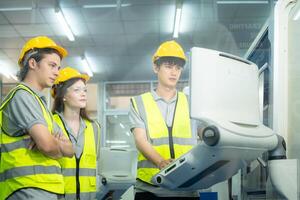 Both of young factory worker wearing a hard hat looking at a computer screen used to control production. photo