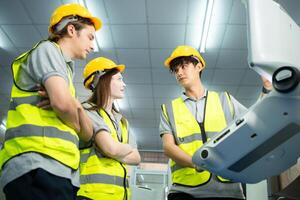 Both of young factory worker wearing a hard hat looking at a computer screen used to control production. photo