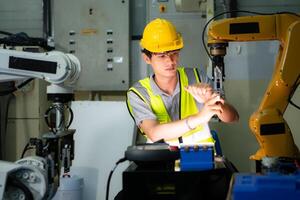 un técnico sufre un mano accidente mientras trabajando con un robot brazo en un fábrica con compañeros de trabajo Proporcionar asistencia foto