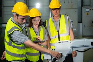 Engineer and technician discussing the robotic arm in factory about work operating, maintenance and repair photo