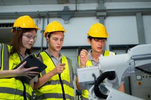 Engineer and technician discussing the robotic arm in factory about work operating, maintenance and repair photo