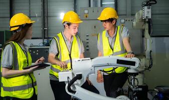 Engineer and technician discussing the robotic arm in factory about work operating, maintenance and repair photo