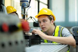 Portrait of a technician young male worker in a factory working on a small robot machine photo