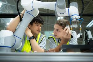 grupo de ingenieros y técnicos aprendizaje el tecnología a controlar mano robots para industrial uso. foto