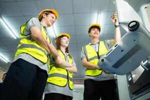 Both of young factory worker wearing a hard hat looking at a computer screen used to control production. photo