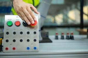 de cerca de mano prensado el detener botón en el controlar panel de un industrial máquina. foto