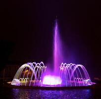 Coloured water fountain at night photo