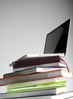 Stack of book and laptop photo