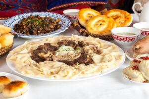 nacional kazakh platos beshparmak, manty, baursak foto