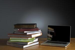 Stack of book and laptop photo