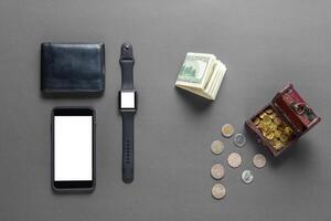 Business concept. Top view of dollars, watch, smartphone on color background photo