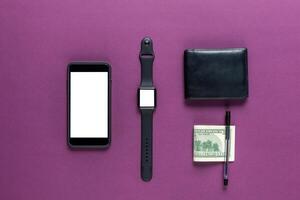 Business concept. Top view of dollars, watch, smartphone on color background photo