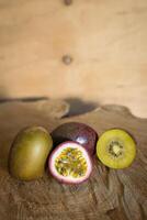 Juicy of passion fruit and kiwi on a wooden background photo