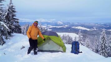 viaggiatore vicino il tenda nel il montagna nel inverno. bellissimo inverno paesaggio. viaggio concetto. video