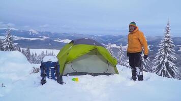 viaggiatore vicino il tenda nel il montagna nel inverno. bellissimo inverno paesaggio. viaggio concetto. video