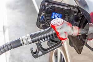 Men hold Fuel nozzle to add fuel in car photo