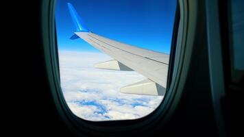 Scenic View from Airplane Window, Clear view from an airplane window showing a wing over cloud-covered skies. video