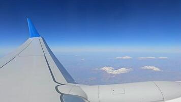 majestuoso montaña rango visto desde avión, maravilloso aéreo ver de un desmadejado montaña rango debajo claro cielo, como visto desde un avión ventana. video