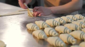 Nahansicht von Damen Hände Verdrehen Bagels mit Himbeere Füllung von das Teig. Damen Hände Twist Stücke von Teig zu machen Kekse video