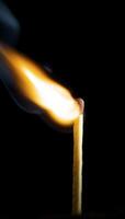 Wooden match burning on a black background photo