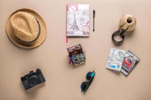 Packed suitcase of vacation items on wooden table, top view photo