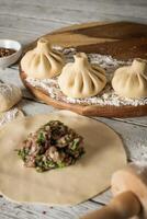 Close up to Caucasian khinkali dumplings dish served on plate. Background with ingredients and scattered spices photo