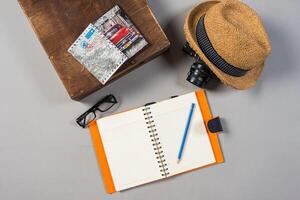 Packed suitcase of vacation items on wooden background. photo