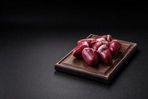 Raw turkey or chicken hearts with salt and spices photo