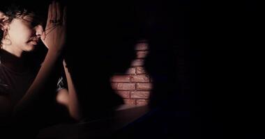 Young Woman Praying In A Dark Room video