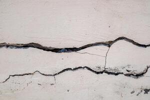 Cracked concrete wall broken wall at the outside cement corner that effected with earthquake and collapsed ground photo