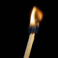 Wooden match burning on a black background photo