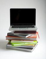 Stack of book and laptop photo