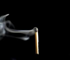 Wooden match burning on a black background photo