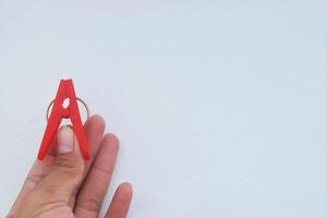 un persona participación un rojo pinza de ropa formando el letra un foto