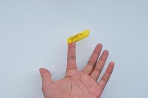 a man's index finger is clamped by a clothespin photo