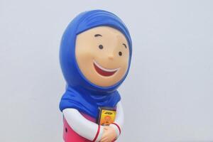 Side view photo of a toy Muslim girl wearing a blue headscarf