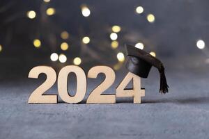 Class of 2024 concept. Number 2024 with graduated cap and bokeh lights. photo