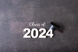 de madera número 2024 con graduado gorra. clase de 2024 concepto. foto