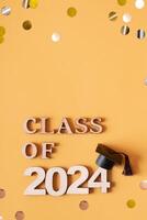 Class of 2024 text with graduated cap on orange. Graduation holiday concept. photo