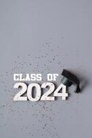 Class of 2024 concept. Number 2024 with graduation cap and confetti photo